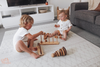 Two kids playing on a large Baby Driver Boho playmat. Side A has a neutral boho pattern.