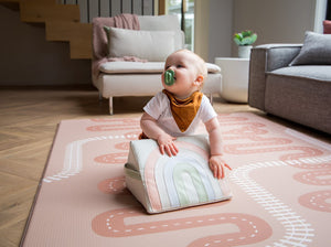 Baby with a tummy time toy on the Baby Driver Dusty Rose Boho playmat. Side B has a car track design.