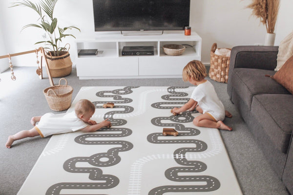 playmat with road track and kids playing with wooden toys