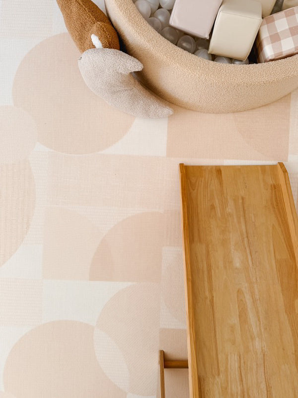 A wooden toy box on a table beside a soft white rug, creating a cozy play area.