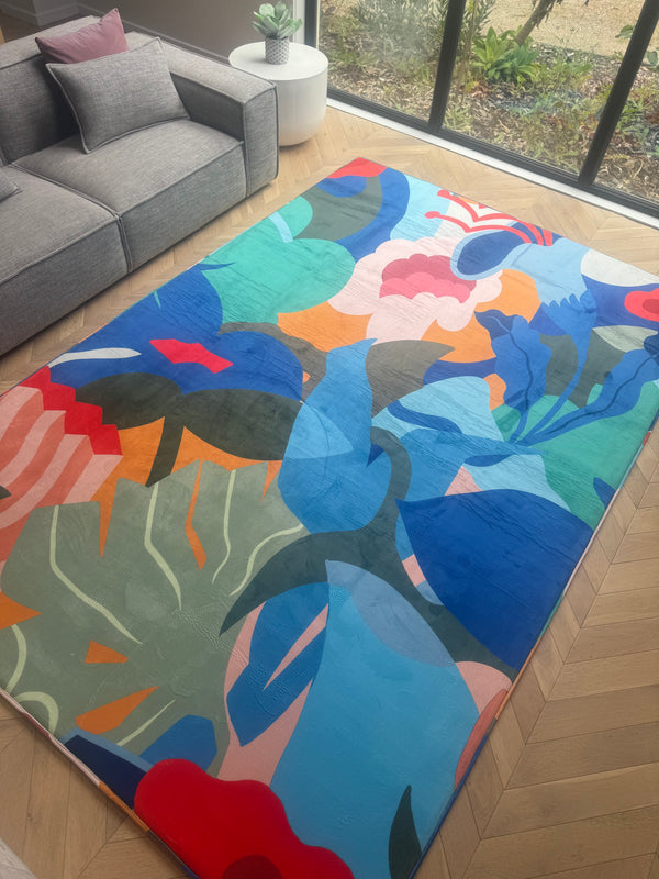 A colorful rug in a living room featuring a couch and a window, creating a cozy and inviting atmosphere.