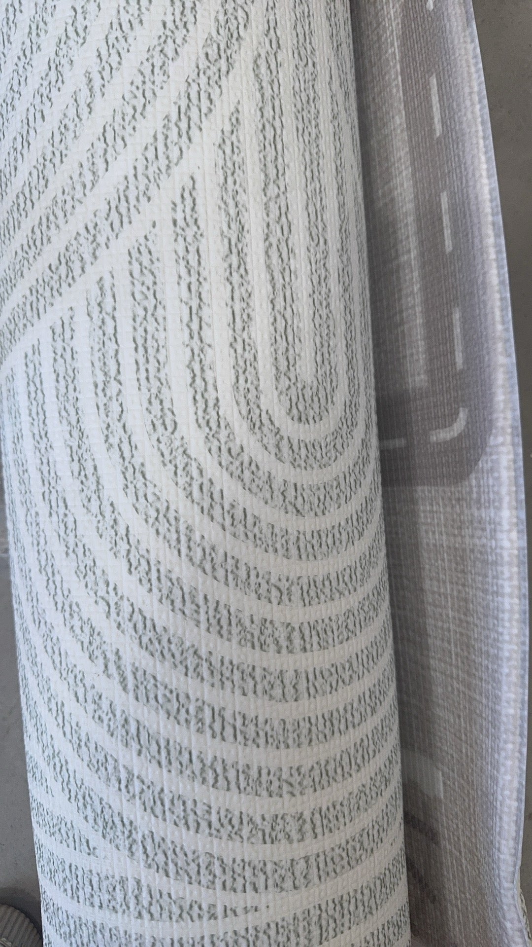 Close-up of a patterned fabric roll showcasing intricate designs and vibrant colors.