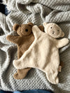 A bear and a bunny stuffed animal are cuddled up on a cozy blanket, creating a warm and inviting scene.