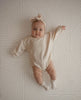 Baby laying on Archie Retro playmat with a neutral arch pattern.