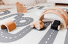 Wooden car toys on Baby Driver Boho Round playmat. Side B has a car track design.