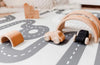 Wooden car toys on Baby Driver Boho Round playmat. Side B has a car track design.