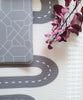 Two sides of Earl Grey Baby Driver playmat. Side A has a grey geometric pattern and side B has a car track design.