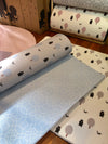 Two sides of Forrest Baby Bluer playmat. Side A has a blue geometric pattern and side B has a tree and bear pattern. 