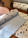 Two sides of Forrest Baby Blue playmat. Side A has a blue geometric pattern and side B has a tree and bear pattern. 