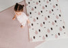 Two sides of Forrest Blush playmat. Side A has a pink geometric pattern and side B has a tree and bear pattern. 