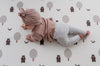 Baby doing tummy time on Forrest Grey playmat. Side B has a tree and bear pattern.