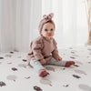 Kid sitting on Forrest Grey playmat. Side B has a tree and bear pattern. 