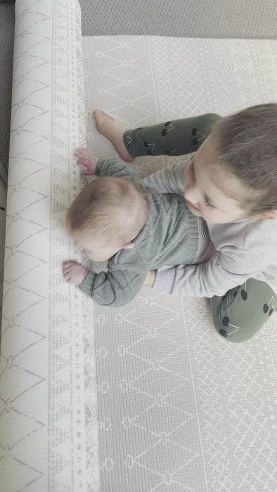 Video of two children playing and rolling out a foam playmat.