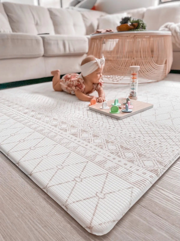 Baby doing tummy time on Baho Boho Grey playmat. Side A has a neutral boho pattern.